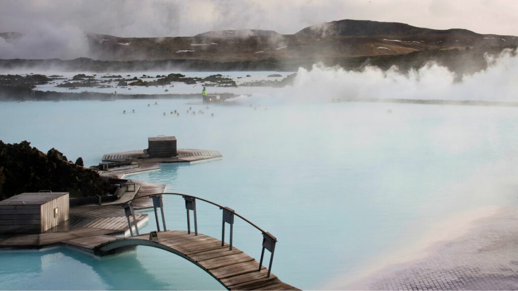 Source géothermique en Islande avec des montagnes en arrière-plan.