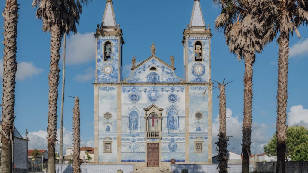 Façade de l'église Igreja Matriz Cortegaça ornée d'azulejos racontant des scènes bibliques.