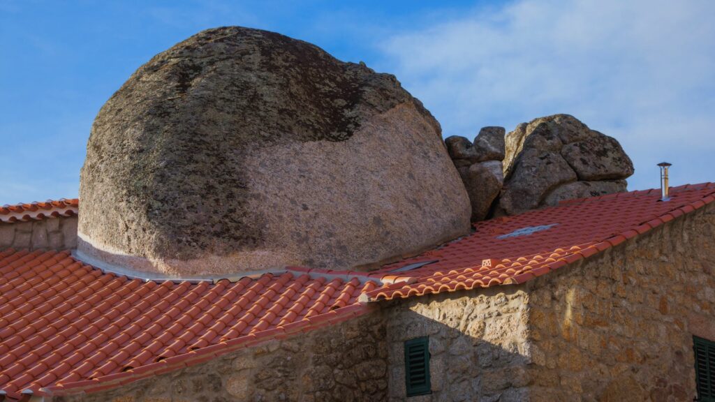 Une maison typique de Monsanto, construite entre les rochers de granit avec un toit de tuiles rouges.