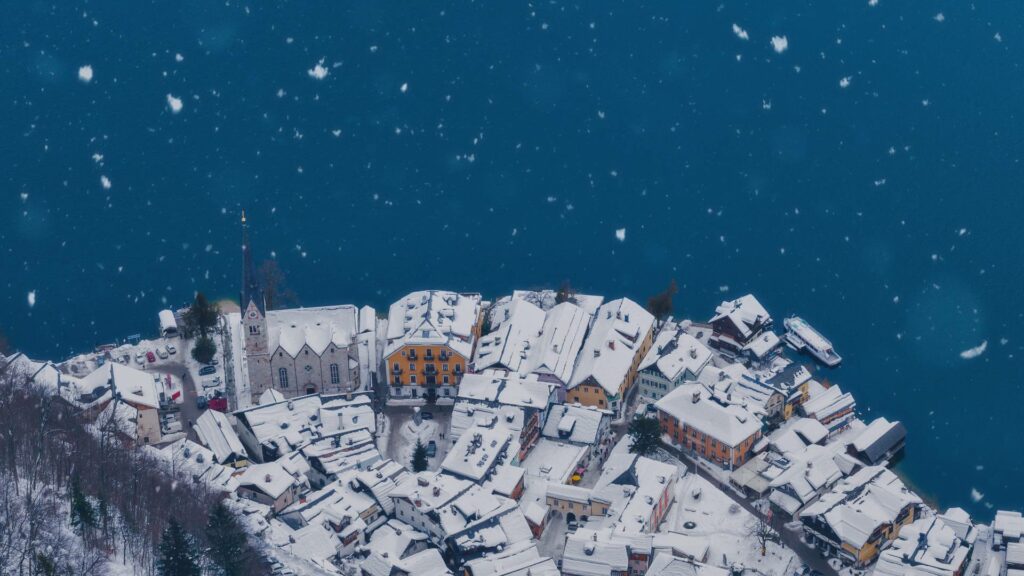 Vue du village de Hallstatt sous la neige, depuis les hauteurs, au bord du lac Hallstätter See, entouré des Alpes autrichiennes.